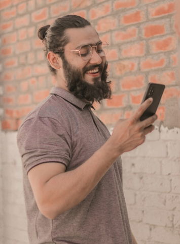 a man with a beard using a cell phone